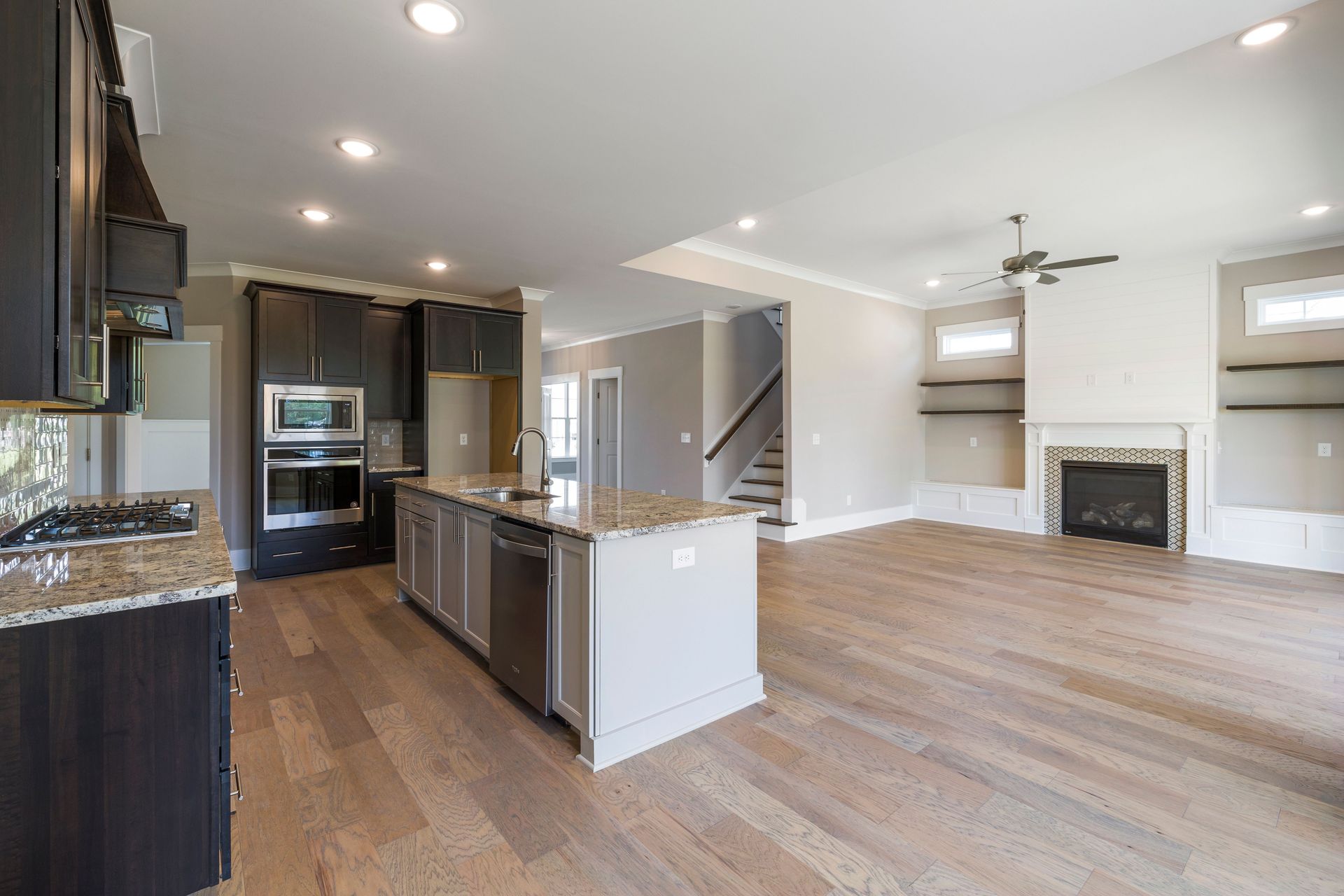 Open concept kitchen and living room with modern design and wooden flooring.